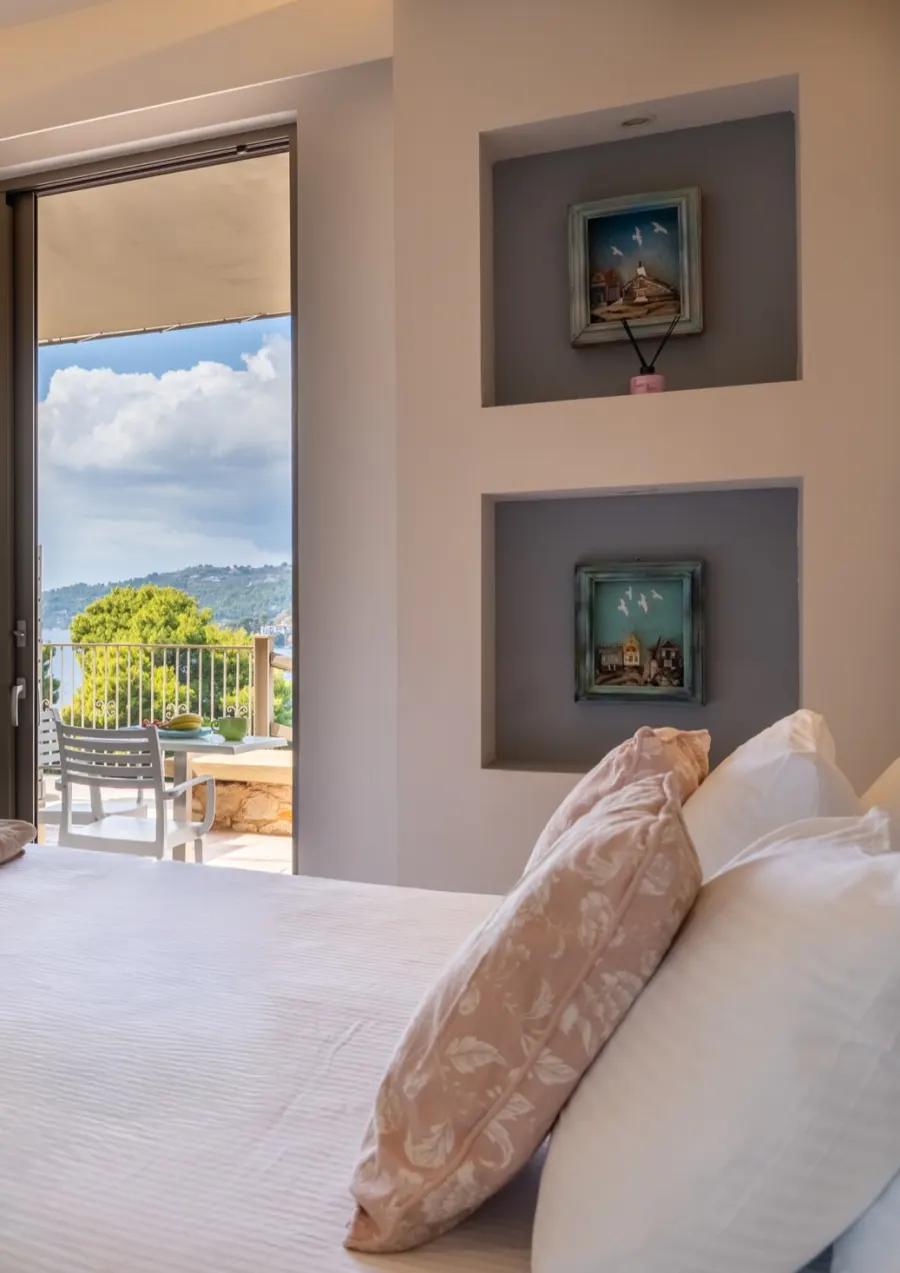 A suite with its door open to the terrace, the bay beyond